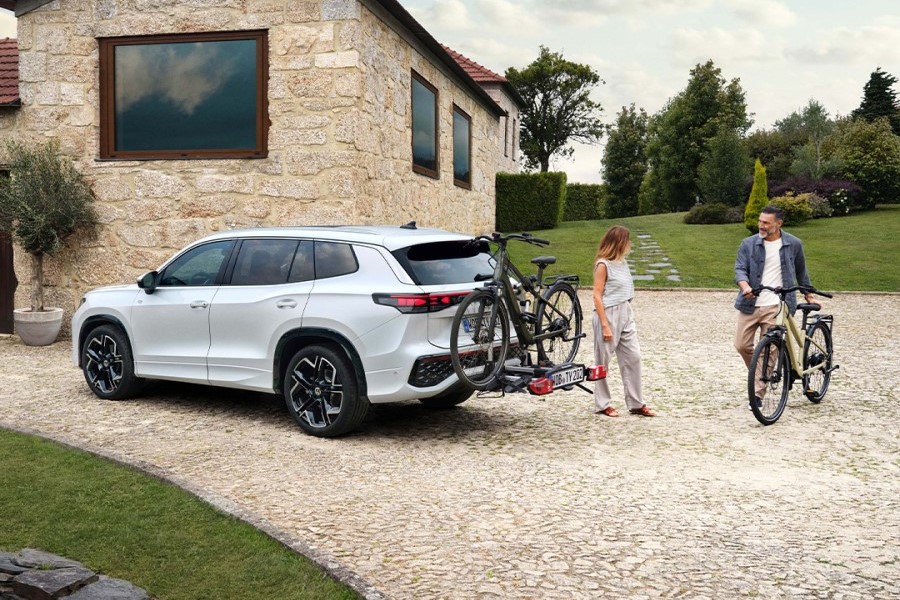 VW Tayron mit Fahrradhäckträger und zwei Personen stehen daneben