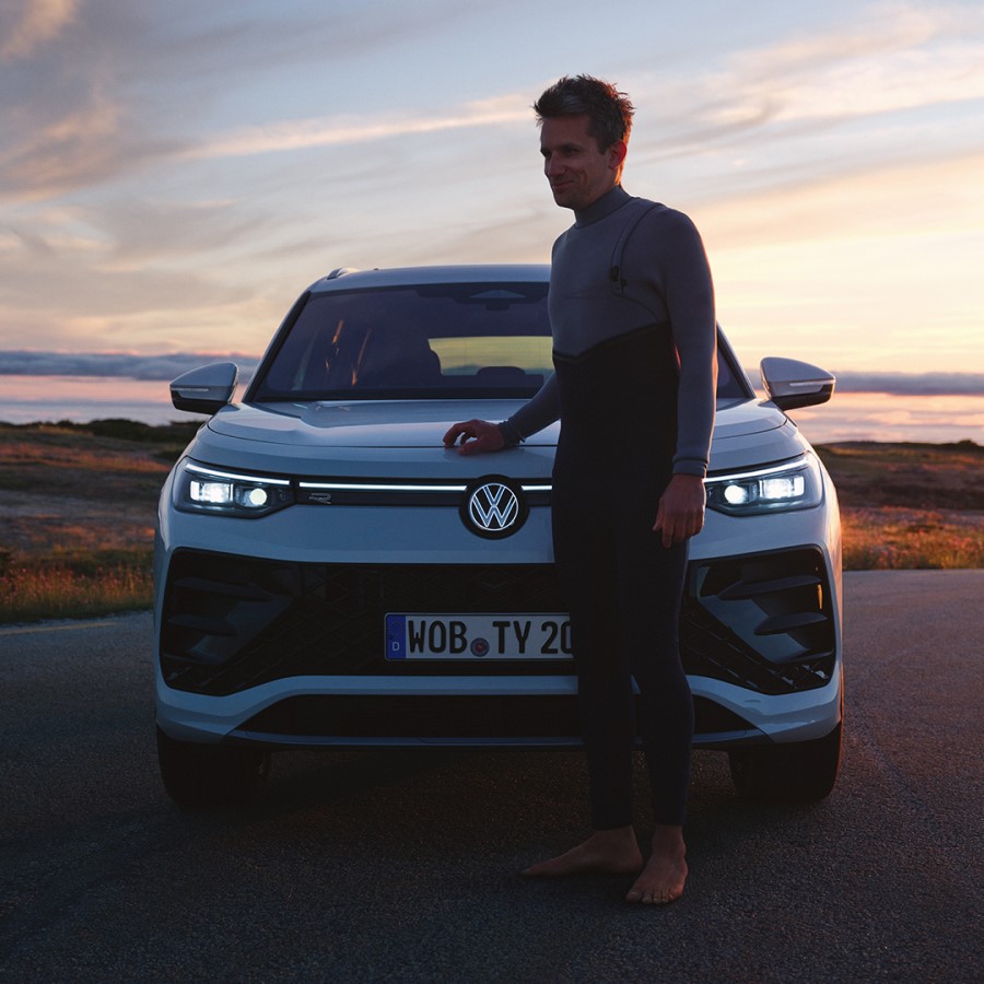 Die Front von einem VW Tayron mit einem Mann davor